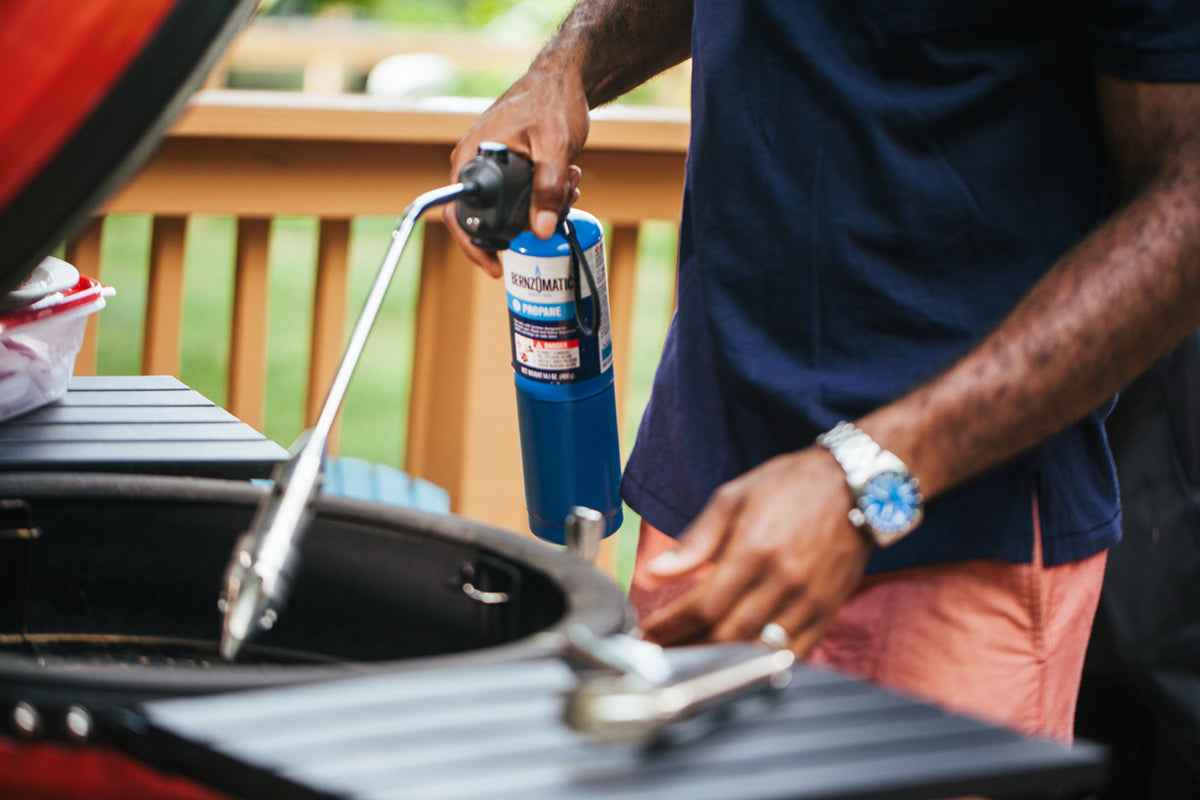 Hand on RocketFire Torch starting a charcoal grill