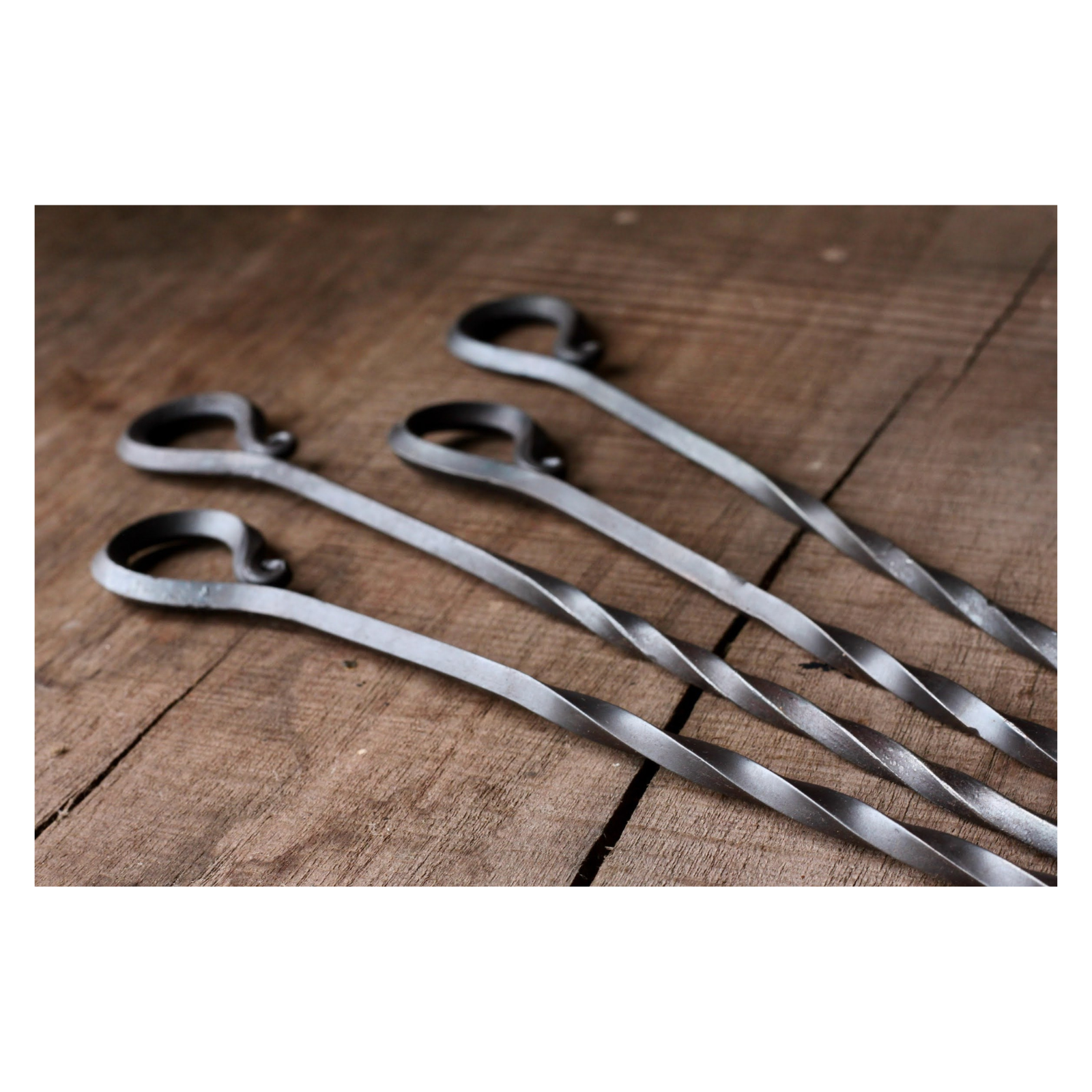 Set of metal skewers on a wooden surface