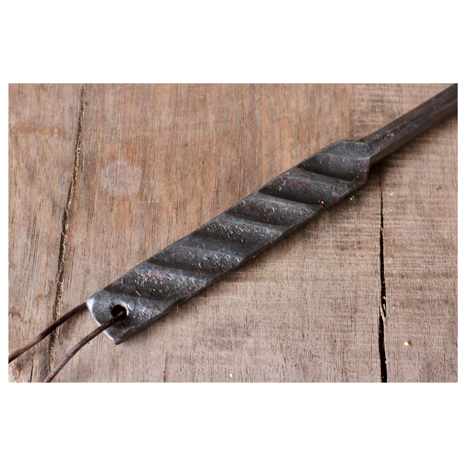 Metal tool with a textured handle on a wooden surface