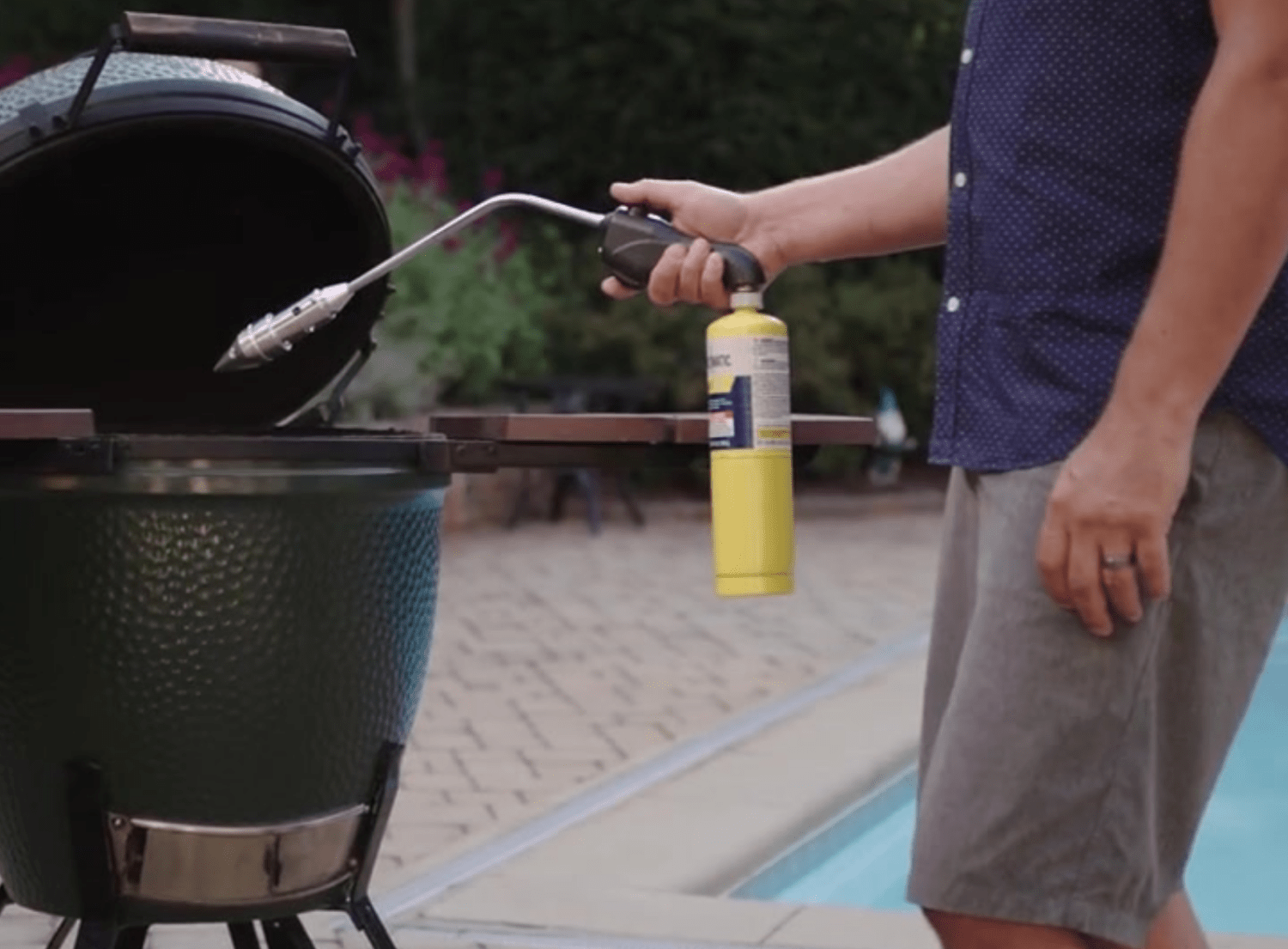 Cooking with a Kamado Grill - Guy with torch lighting kamado
