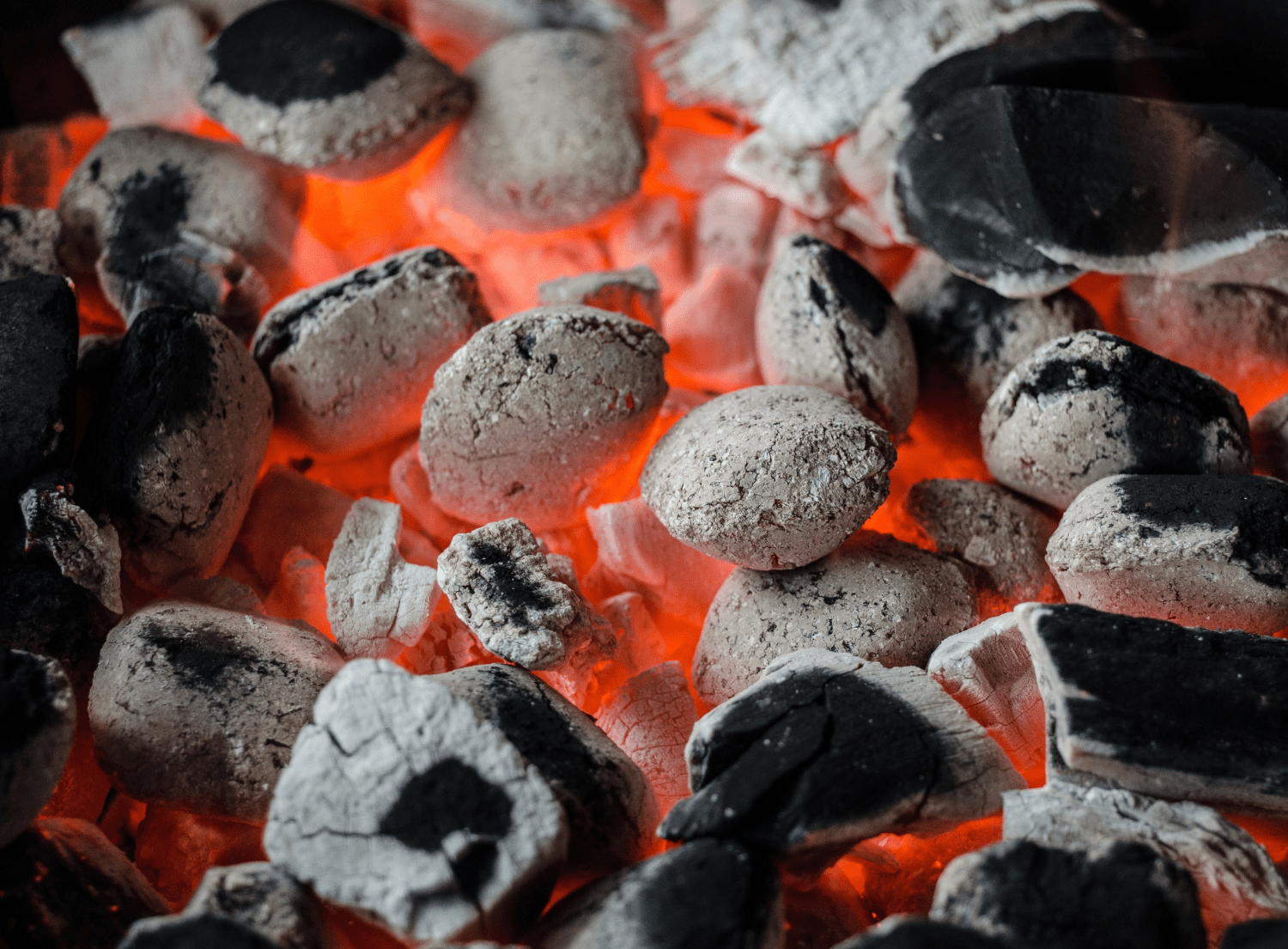 charcoal briquettes burning on a grill. 