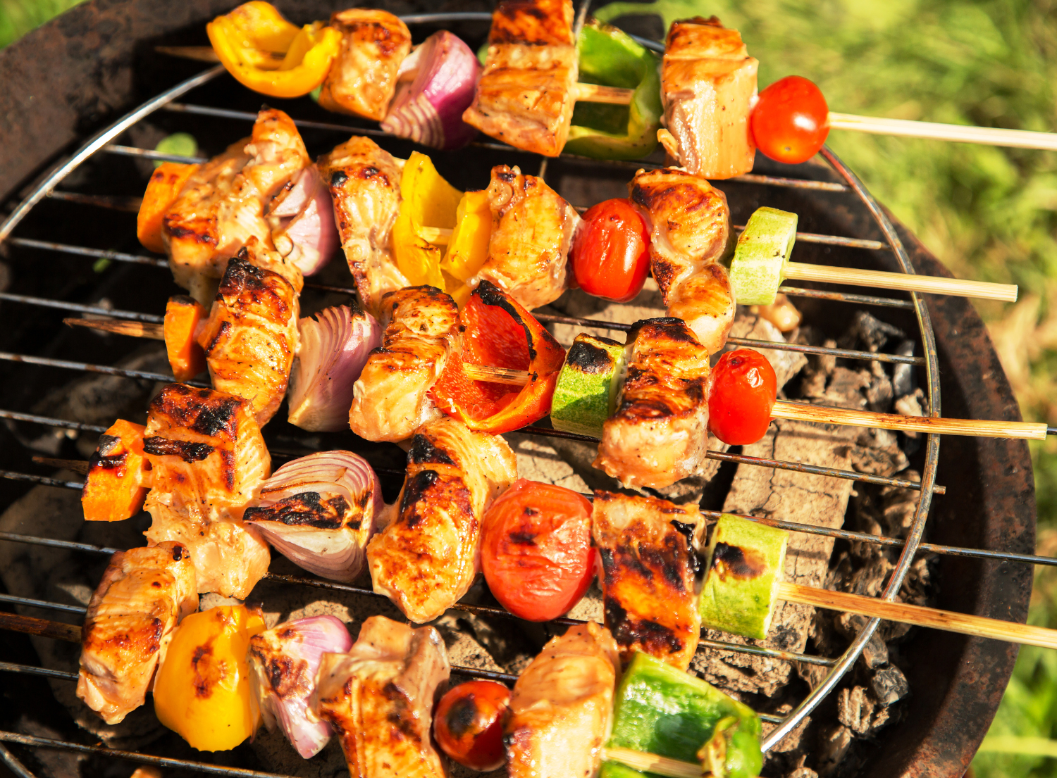 chicken and vegetable skewers being cooked on a grill