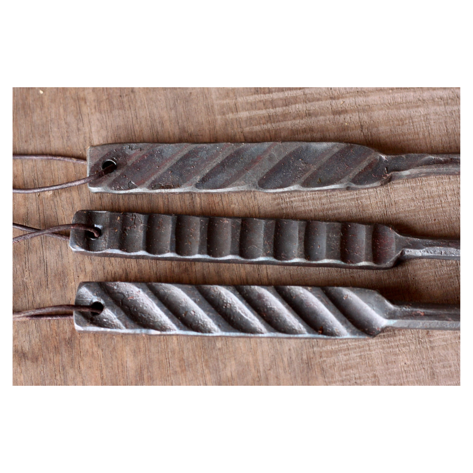 Three metal tools with textured surfaces on a wooden background