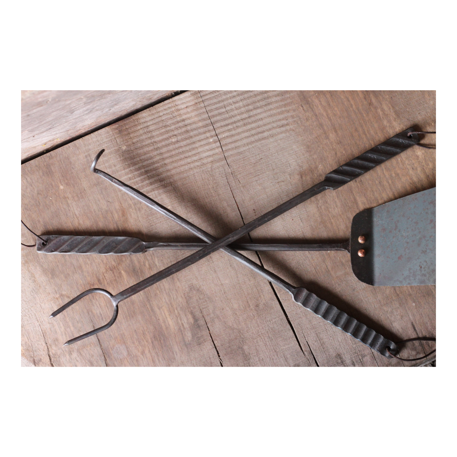 Set of metal fireplace tools on a wooden surface