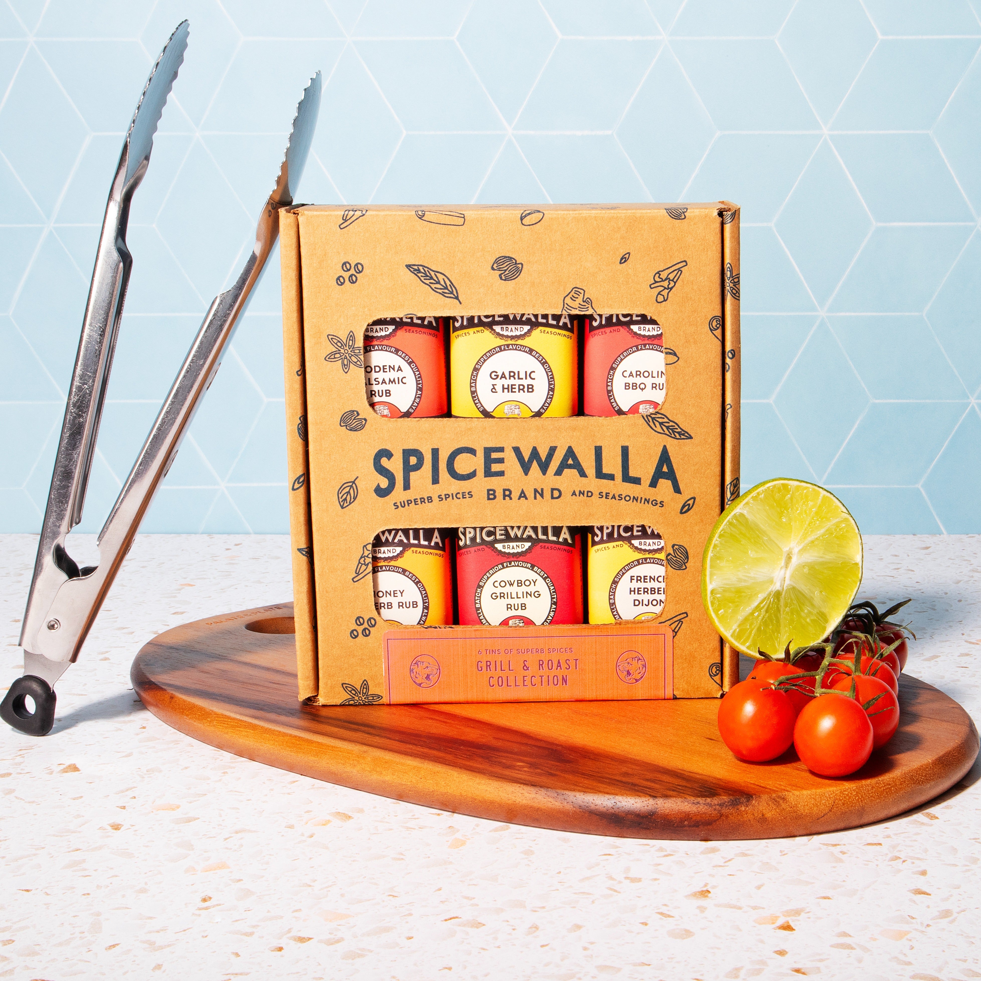 Spicewalla spice collection on a wooden board with a blue tiled background