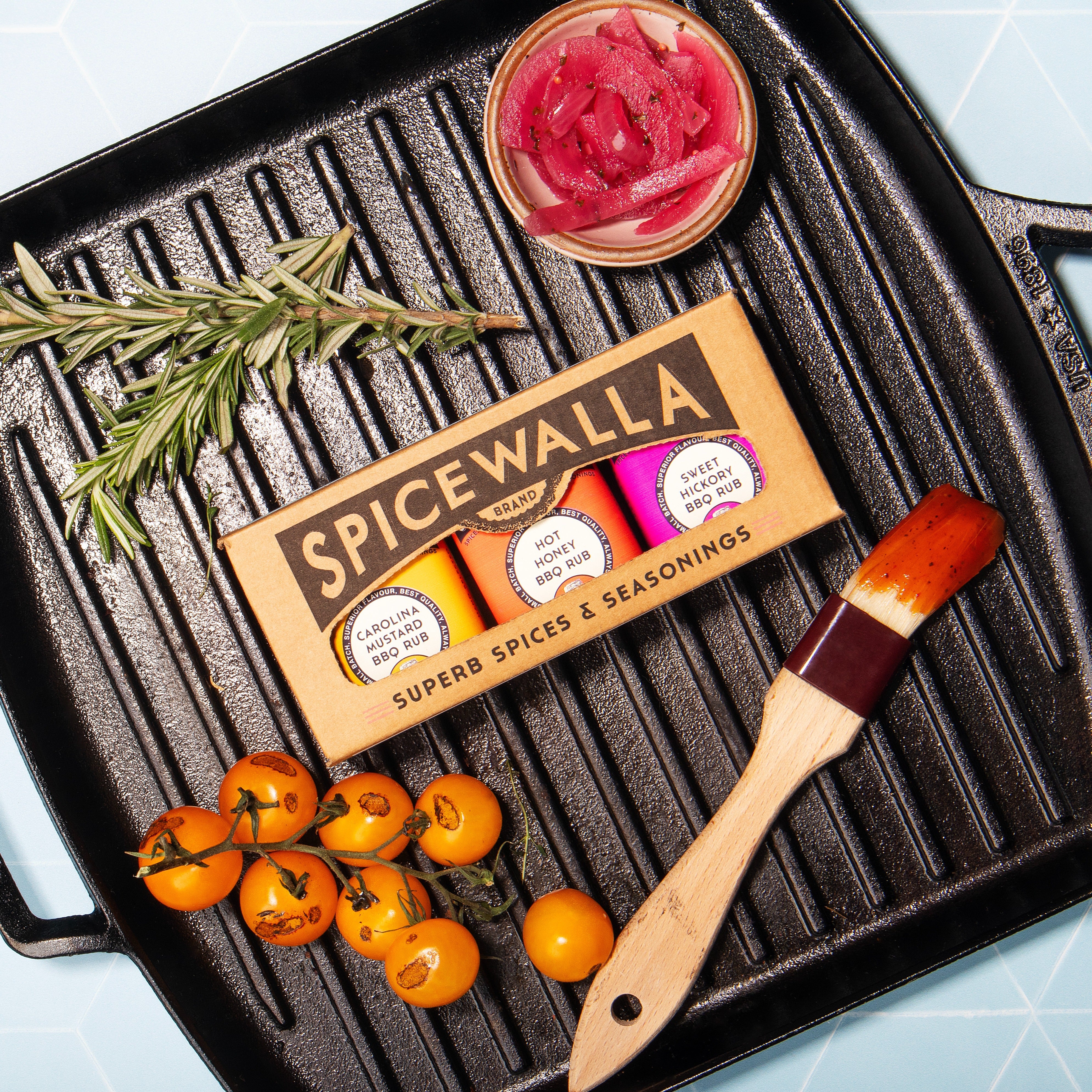 SpiceWalla seasoning box on a grill with tomatoes and a brush